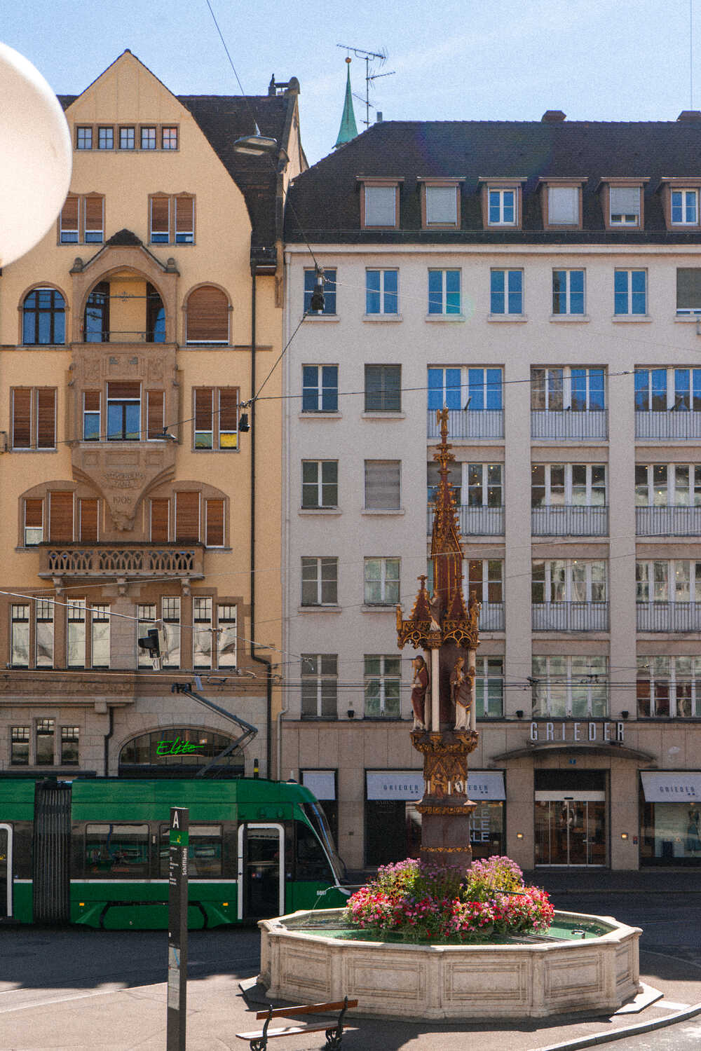 Beautiful architecture of the Old Town in Basel with fountain and green tram